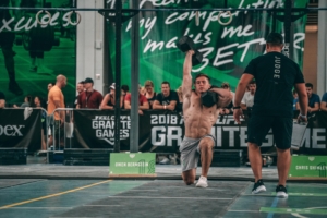 A man holding a kettlebell in the air.